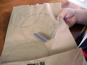 Cut threw all layers of the paper bag, and make a pile of circles.  (1 bag = 1 flower)  By cutting close to the edge, you should get three circles from each cut. (The third comes from the fold)