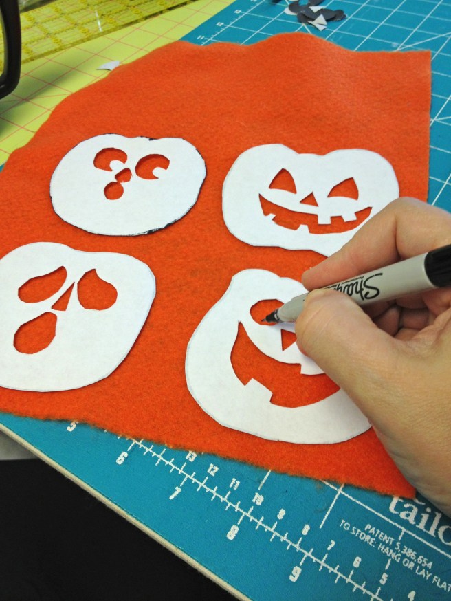 Place pumpkin templates FACE DOWN on orange felt and outline pumpkins and faces with marker. This will be the wrong side of the pumpkins, and ink won't show on other side.